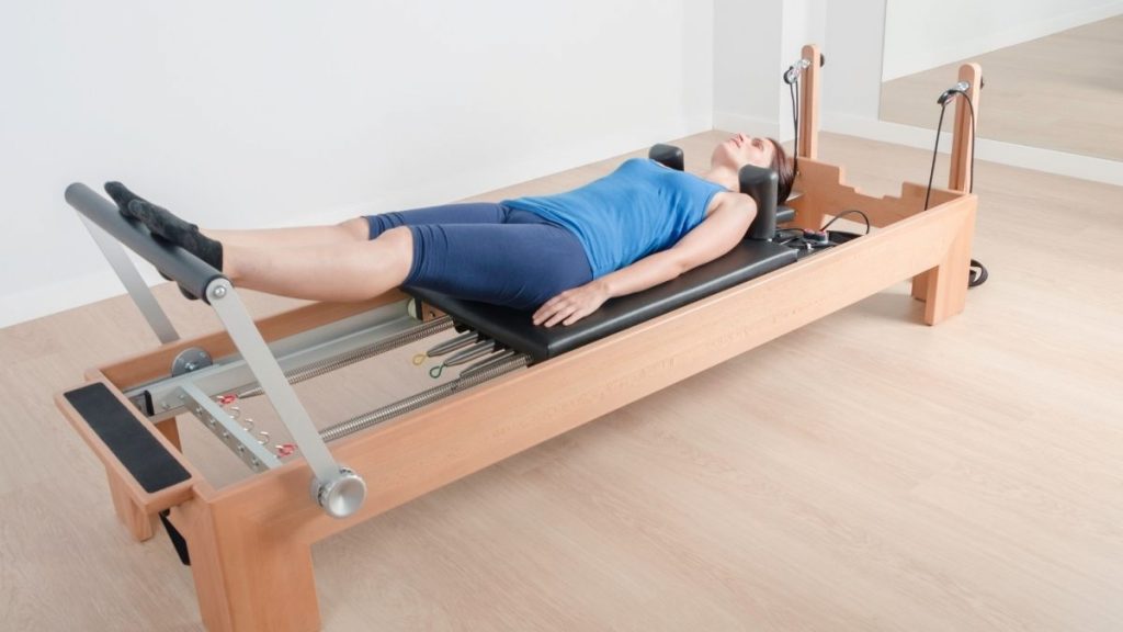 lady lying down on the reformer