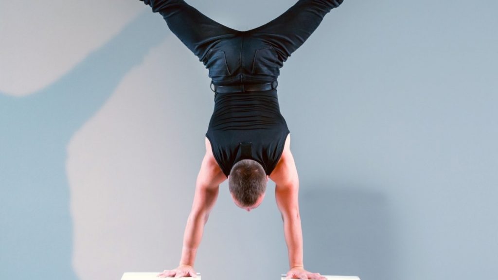 a man demonstrating a straddle handstands